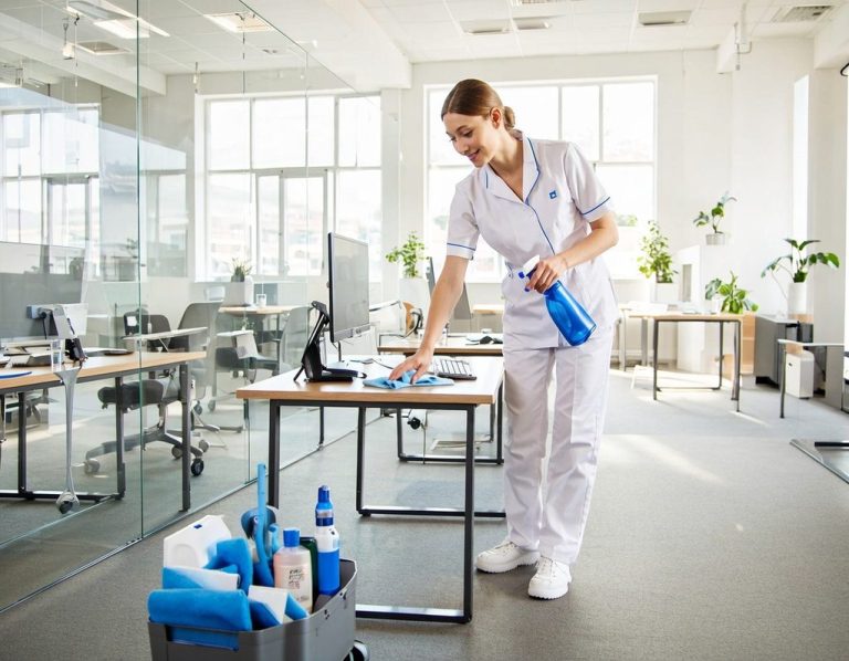 Büroreinigung in Kirchheim unter Teck und Stuttgart Eine Reinigungskraft putzt einen Schreibtisch in einem modernen Büro.
